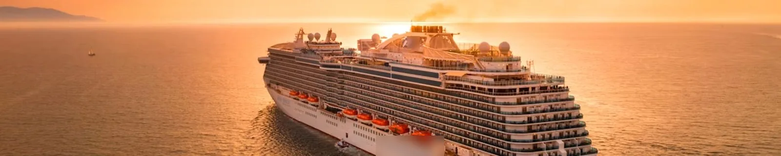 A cruise ship at sea at sunset